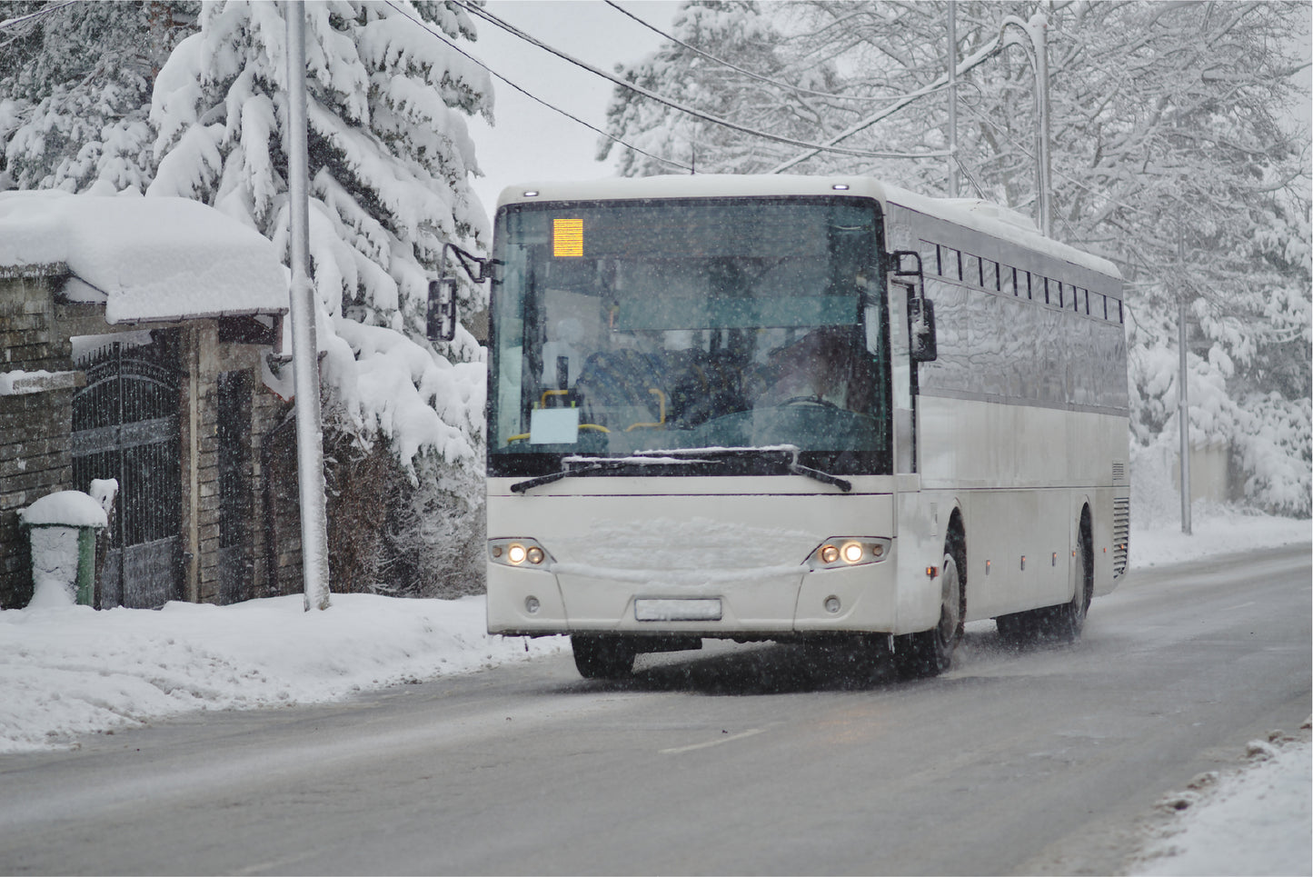 Bus, road, and surrounding landscape covered in snow. Winter vacation nj ski bus trip.