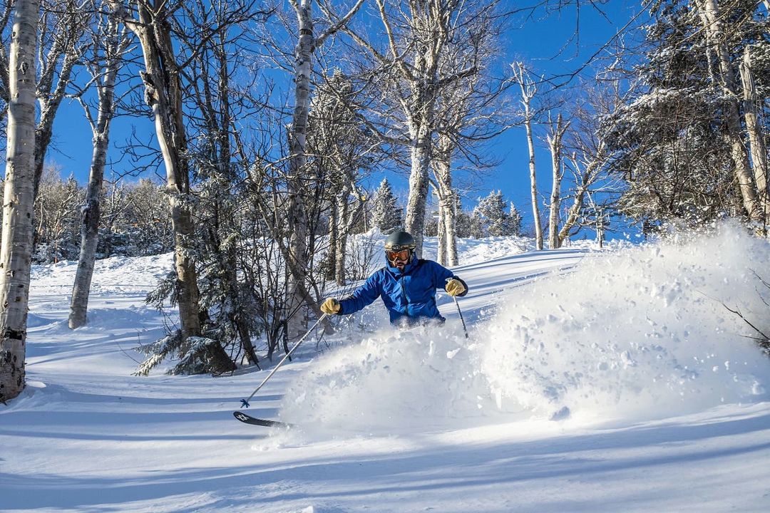 Person in blue jacket making first tracks on skis in Vermont.
